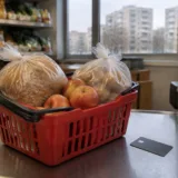 Produse alimentare într-un coș lângă un card bancar la casa de marcat